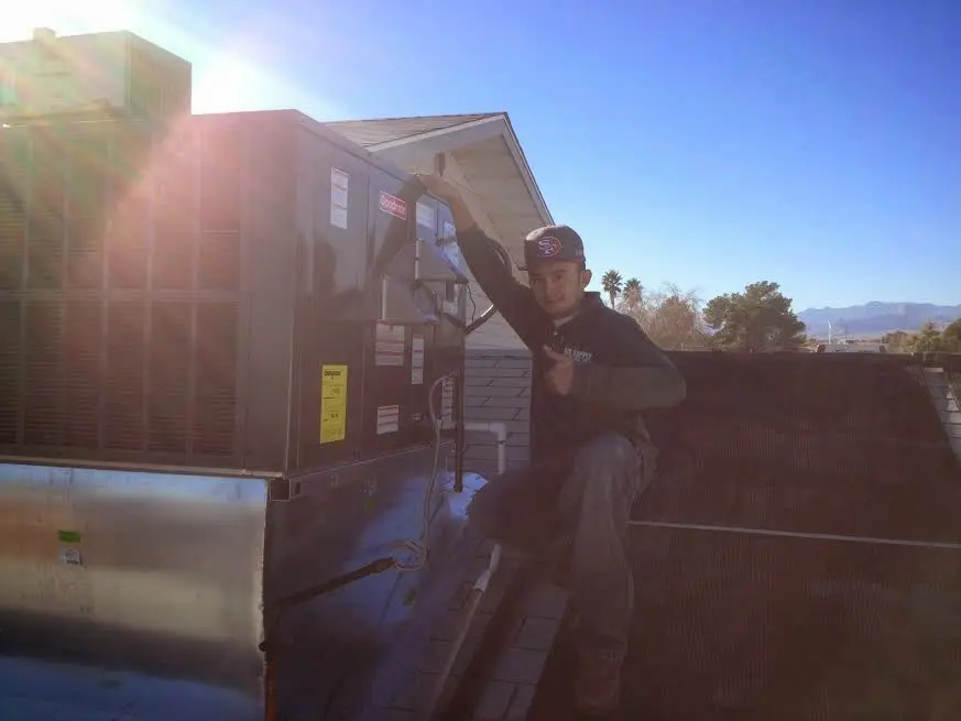 HVAC technician performing Air Duct Repair on a rooftop unit in Swainsboro